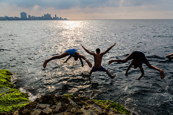 Boys jumping off the sea wall in Havana, Cuba